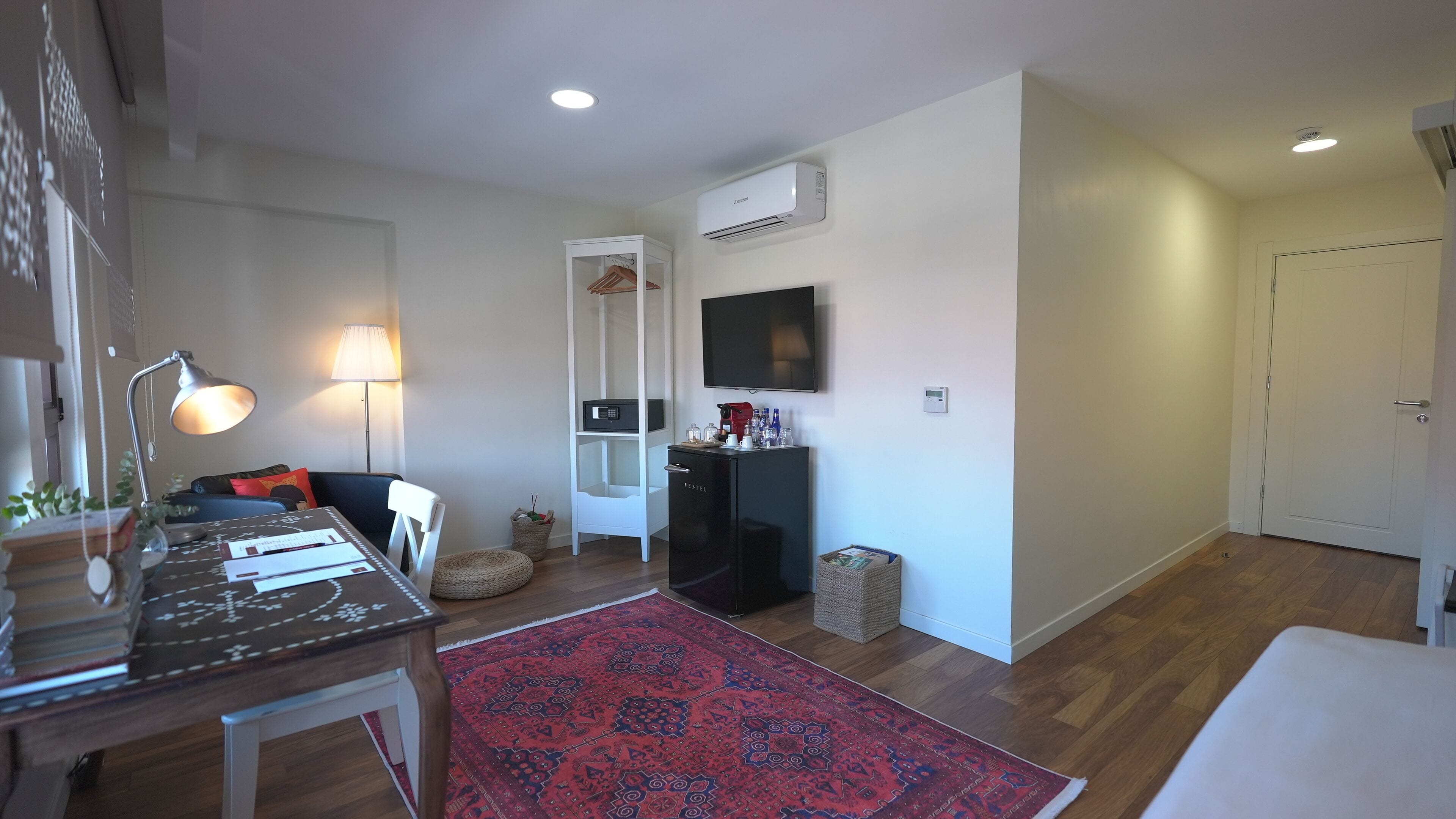 A modern living room with a coffee machine, TV, and a bookshelf.