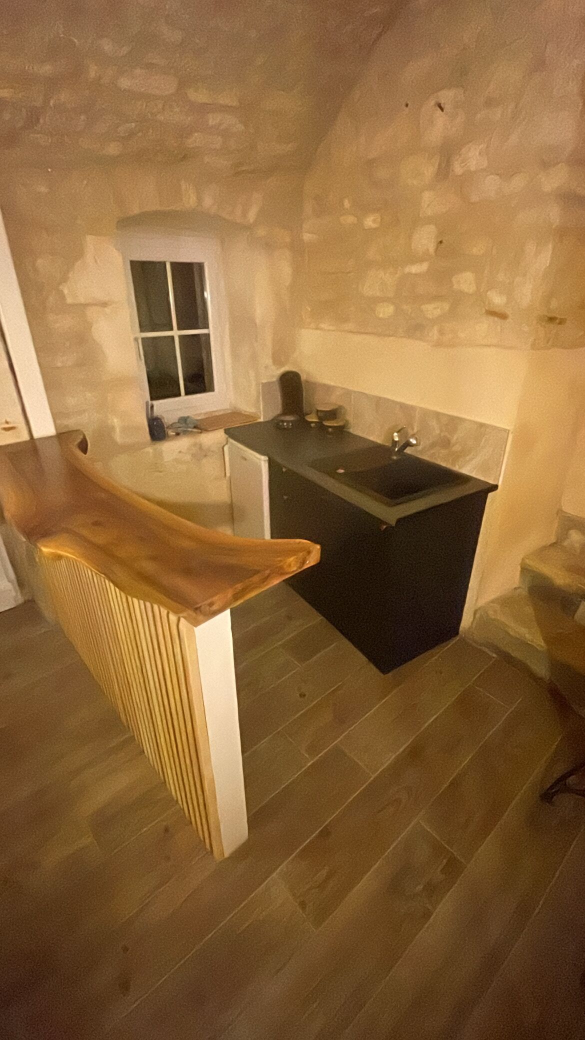A kitchen with a wooden countertop, a sink, and a window.
