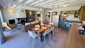 A modern kitchen with a dining area, a fireplace, and a TV. - Villa "Calypso" (SEIGNOSSE)