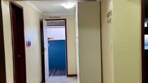 A hallway with tiled flooring and cream-colored walls. - Prédio Atalaia  (Arraial do Cabo)
