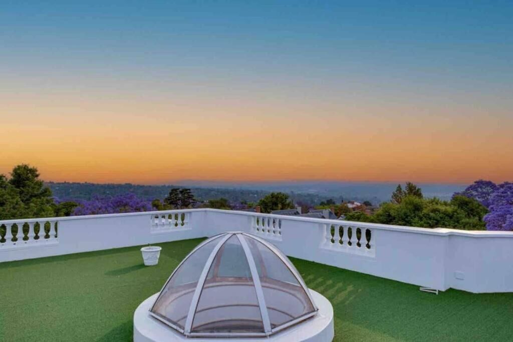 A rooftop terrace with a clear view of the city skyline at sunset.
