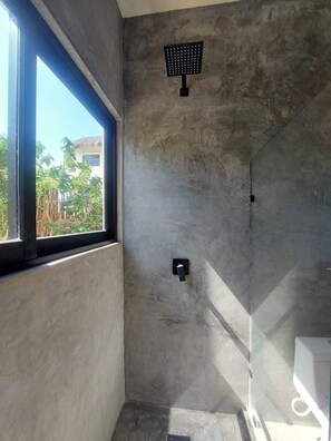 Un bany modern amb una finestra gran, un vàter i un lavabo.