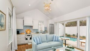 A modern kitchen with white cabinets, a stainless steel refrigerator, and a patterned backsplash. - Bijou: Chloe | Luxury Cottage | Plunge Pool | Full Kitchen | Seasonal Fireplace (Fredericksburg)