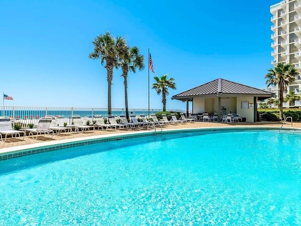 A clear blue pool with lounge chairs, palm trees, and a small pavilion. - BREATHTAKING VIEWS!! Comfortable & casual. Wonderful pools. On-site gym (Orange Beach)
