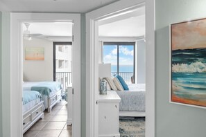 A bedroom with a bed, bedside tables, and a window with a view.