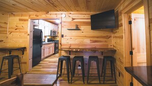 Un interior de madera con cocina, barra y zona de estar.