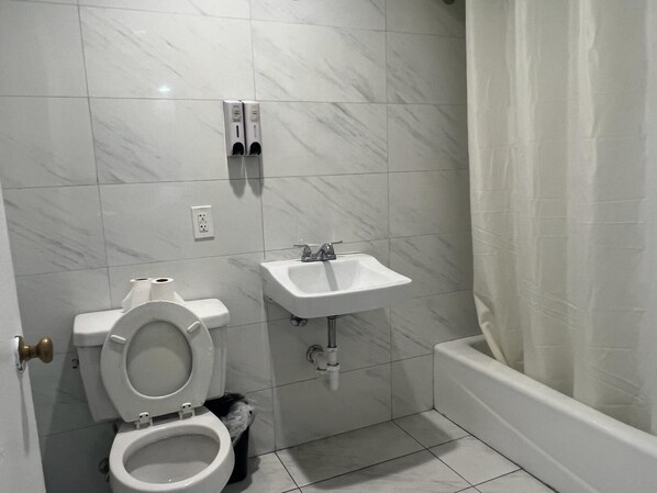 A bathroom with a toilet, sink, and bathtub.