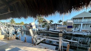 A marina with boats docked, a waterway, and a building in the background.
