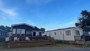 Een rij vakantiehuisjes met een houten terras en een bord met het nummer 16.
