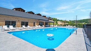 Una piscina amb gandules i un edifici de fusta al fons.