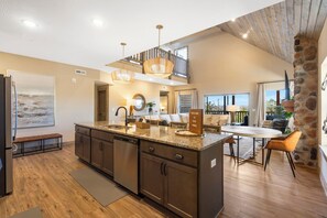 A spacious kitchen with a large island, dark cabinetry, and a stone accent wall.