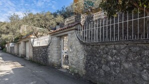 A stone wall with a metal gate, a paved road, and trees in the background. - Comfortable apartment perfect for 4 people and surrounded by greenery, it is located in a quiet area, a few steps from the beaches of Lerici. The house is equipped with every comfort, 2 bathrooms, kitchen, TV, WiFi, private parking. Ideal opportunity to  (Lerici)