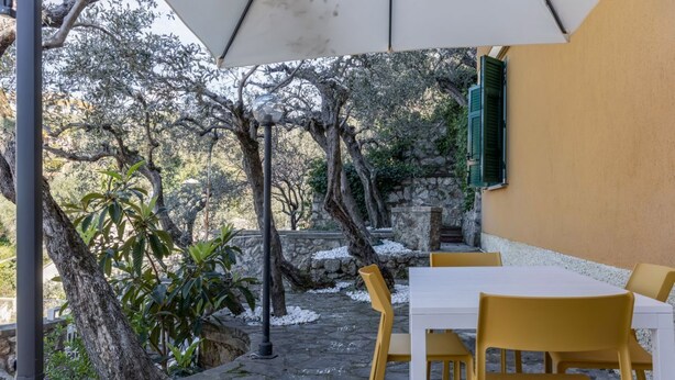 A patio area with a table and chairs, a lamp post, and a stone pathway. - Comfortable apartment perfect for 4 people and surrounded by greenery, it is located in a quiet area, a few steps from the beaches of Lerici. The house is equipped with every comfort, 2 bathrooms, kitchen, TV, WiFi, private parking. Ideal opportunity to  (Lerici)