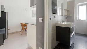 A modern bathroom with a sink, mirror, and shower.