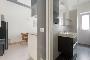 A modern bathroom with a sink, mirror, and shower.