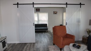 Una sala moderna con un sofá, una silla y una mesa de comedor.