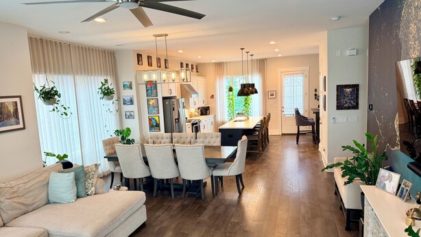 A spacious living area with a sofa, dining table, and chairs, a kitchen with a refrigerator, and a ceiling fan. - Spacious 2 BR Urban Oasis at Castleberry Station in downtown Atlanta (Atlanta)