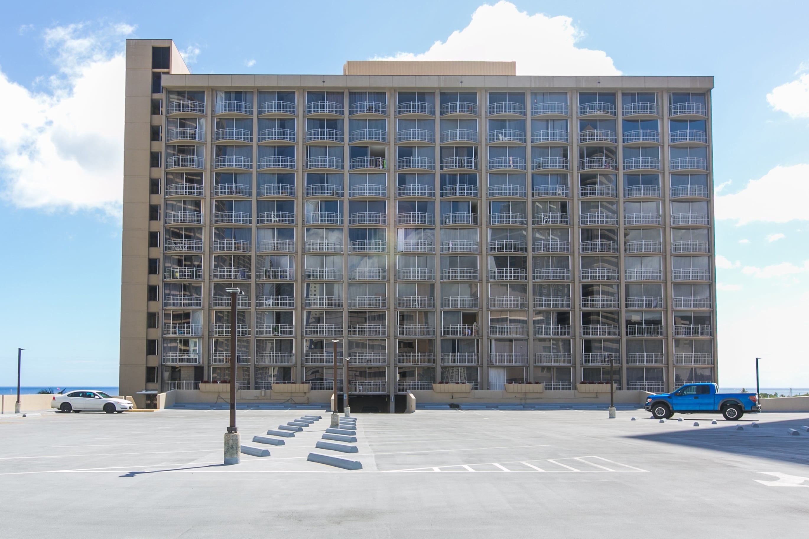 Un edificio de varios pisos con fachada uniforme, ventanas amplias y techo plano.