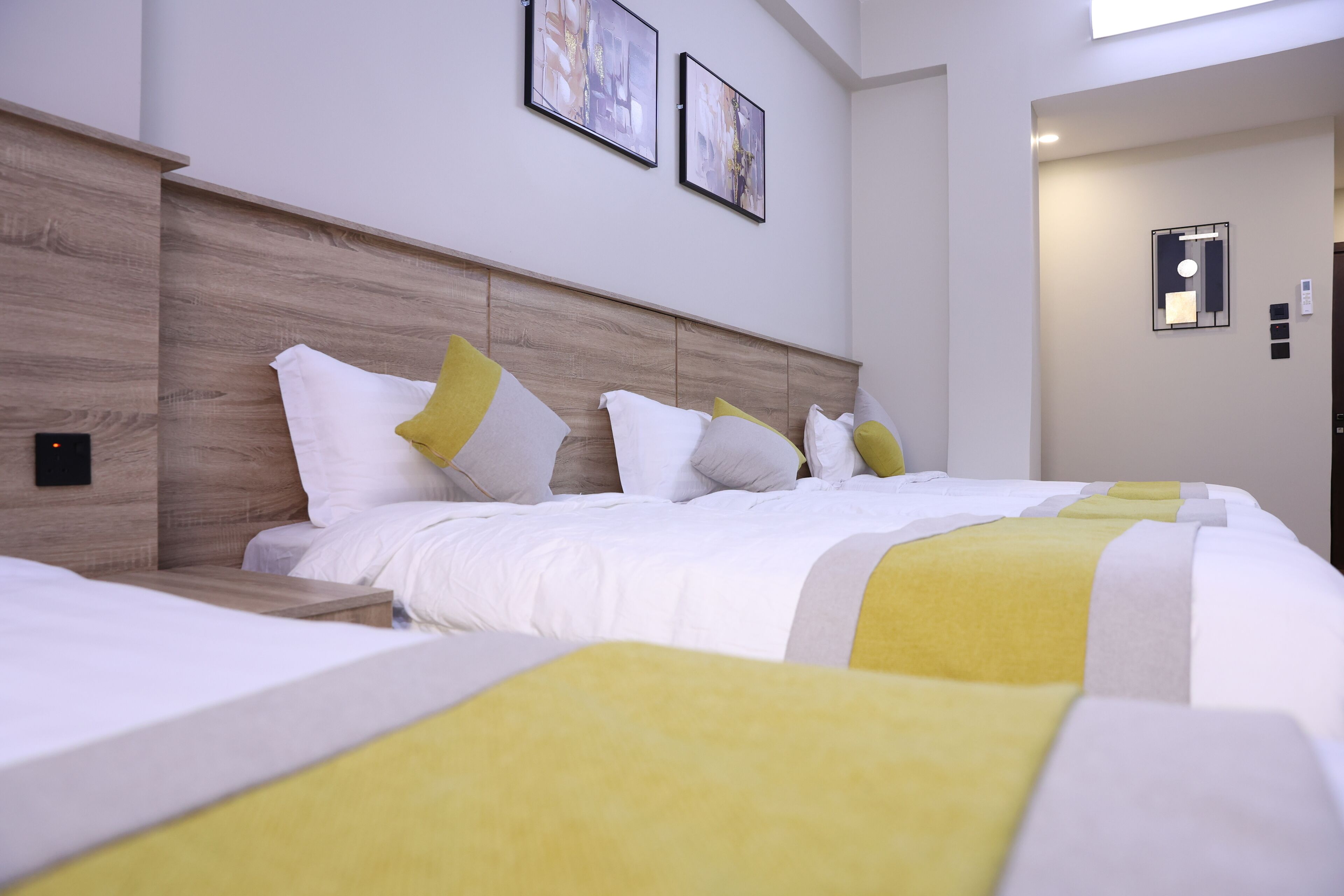 A hotel room with a large bed, a bedside table, and a wall-mounted light fixture.
