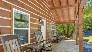 A wooden cabin with a porch featuring rocking chairs and a lantern. - The "Lost Horse" Cabin - Secluded - Pet-Friendly - One Level - Massive Yard (Sevierville)