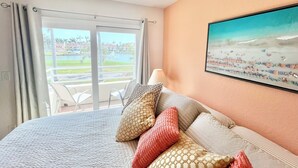 Habitación de hotel con cama, vista a un campo de golf y un cuadro en la pared.
