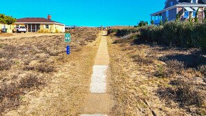 A pathway leading to a building with a clear blue sky. - Cuckoo's Nest - 4 Bed, 2 Bath dog friendly home with pool, hot tub and tiki bar! (Southern Shores)