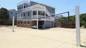 A two-story building with a balcony and a covered area, likely a beach house. - Sea Vista - Oceanside 6 Bed, 5.2 Bath, Rec Room, Pool, Hot tub! (Duck)