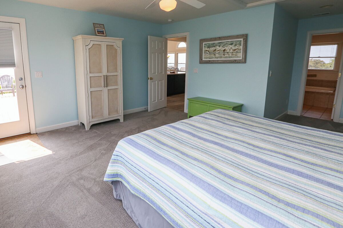 A bedroom with a bed, a wardrobe, and a green chest of drawers.