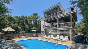 A swimming pool with lounge chairs and a wooden deck area. - Serenity-Too - Oceanside Relaxation, 6 Bed, 4.1 Bath, pool, hot tub, dog friendly! (Southern Shores)