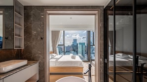 Ein modernes Badezimmer mit einer großen Badewanne, einem Waschtisch mit Spüle und einer Duschkabine aus Glas.