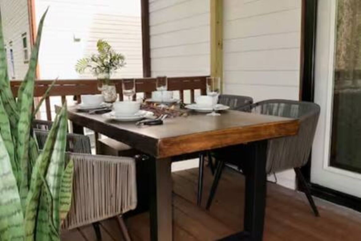 Une table à manger dress ée avec des assiettes, des verres et un vase rempli de fleurs.