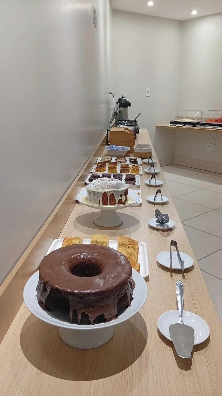 Een buffet met diverse desserts en een koffieapparaat.