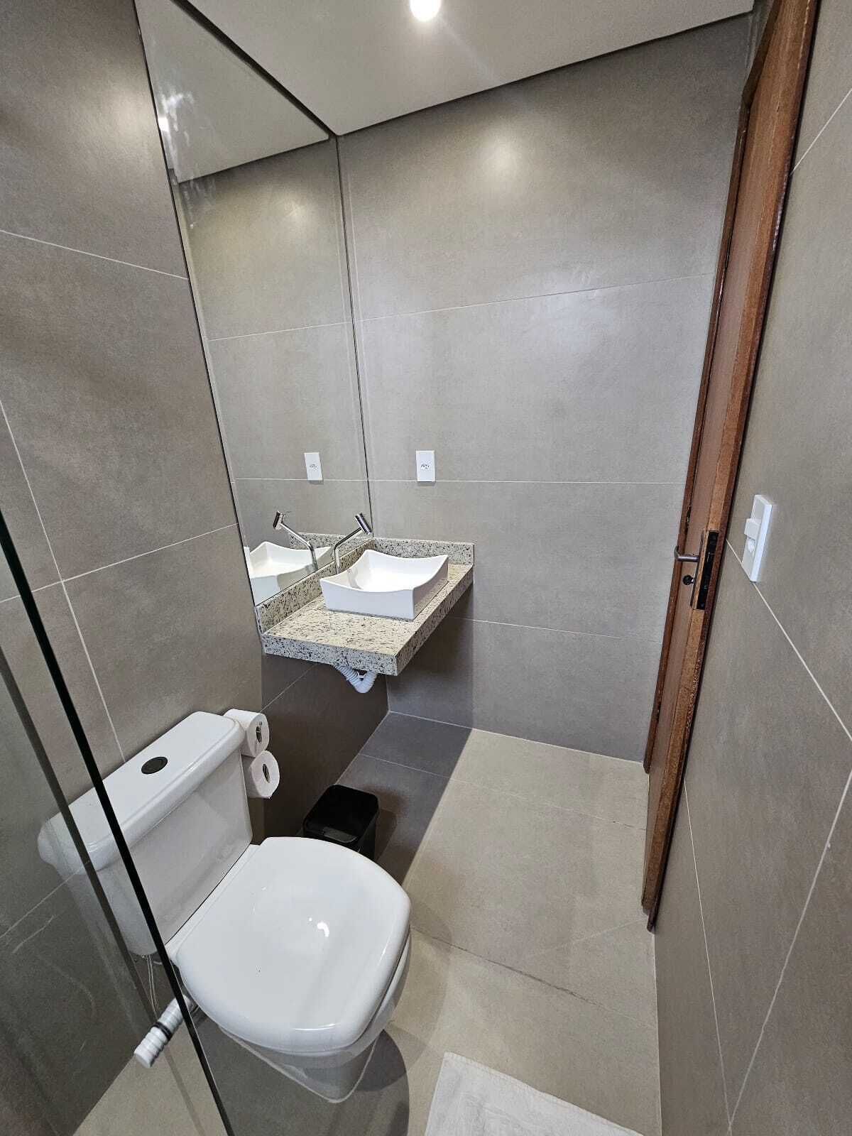 Casa de banho moderna com sanita, lavatório e zona de duche.