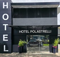 Una entrada de hotel moderna con el nombre 'HOTEL POLASTRELLI' bien visible.