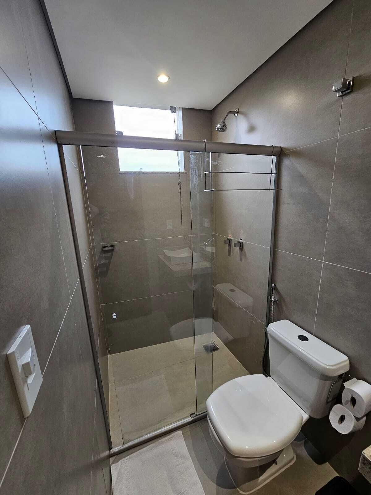 Un baño moderno con ducha envuelta en vidrio, inodoro y bidé.