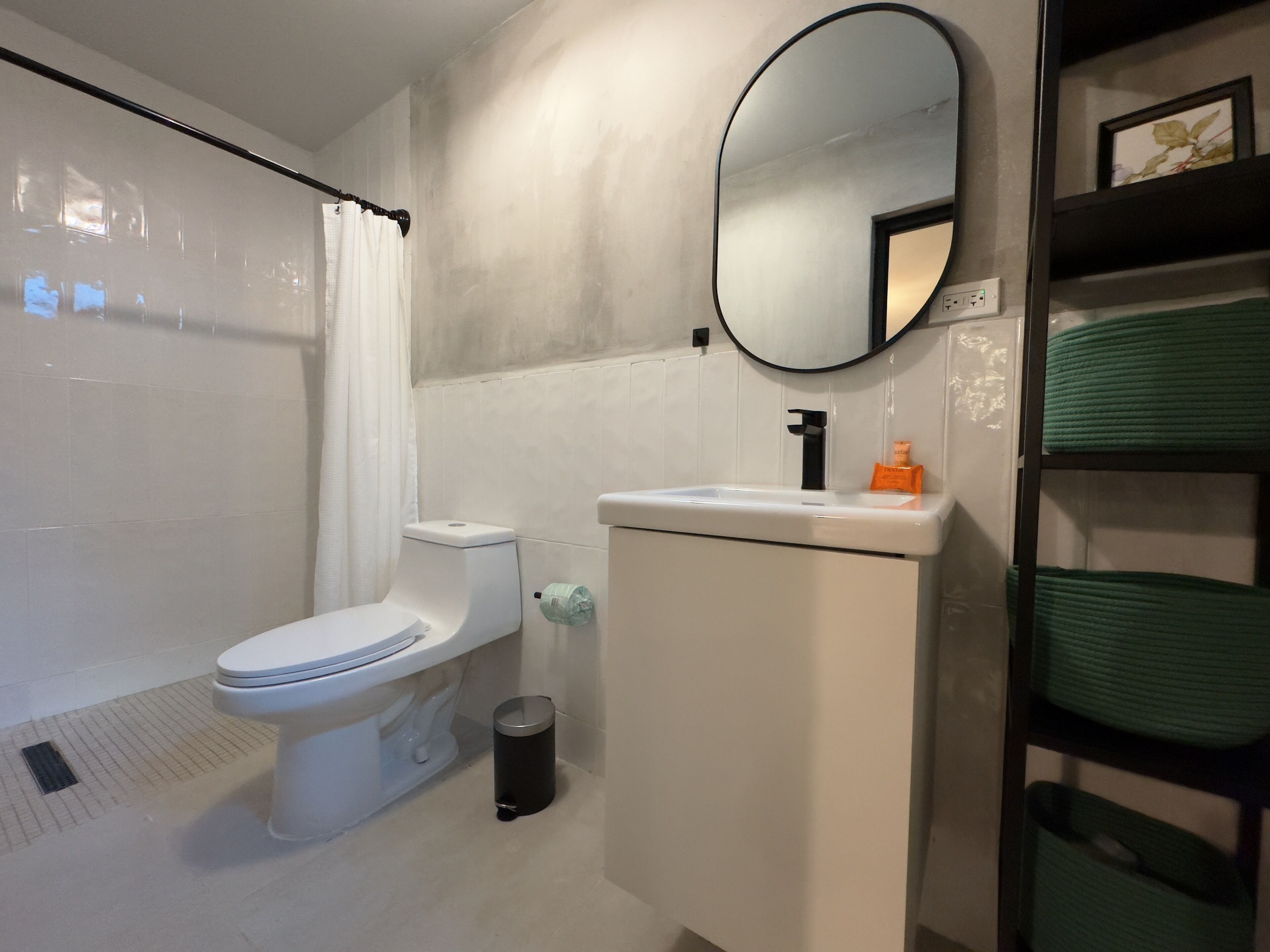 Ein modernes Badezimmer mit Toilette, Waschbecken und Spiegel.