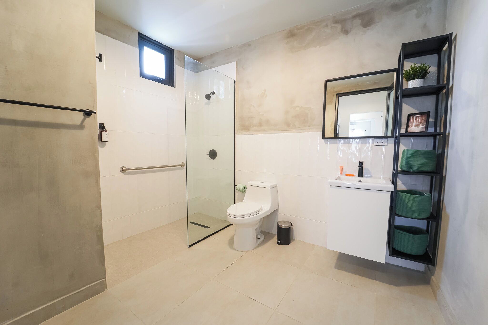 A modern bathroom with a glass shower enclosure, a white toilet, and a built-in sink with a mirror above it.