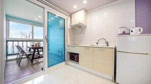 A modern kitchen with a built-in oven, a sink, and a refrigerator. - Gyeongju Nunkoip Pension (Gyeongju)