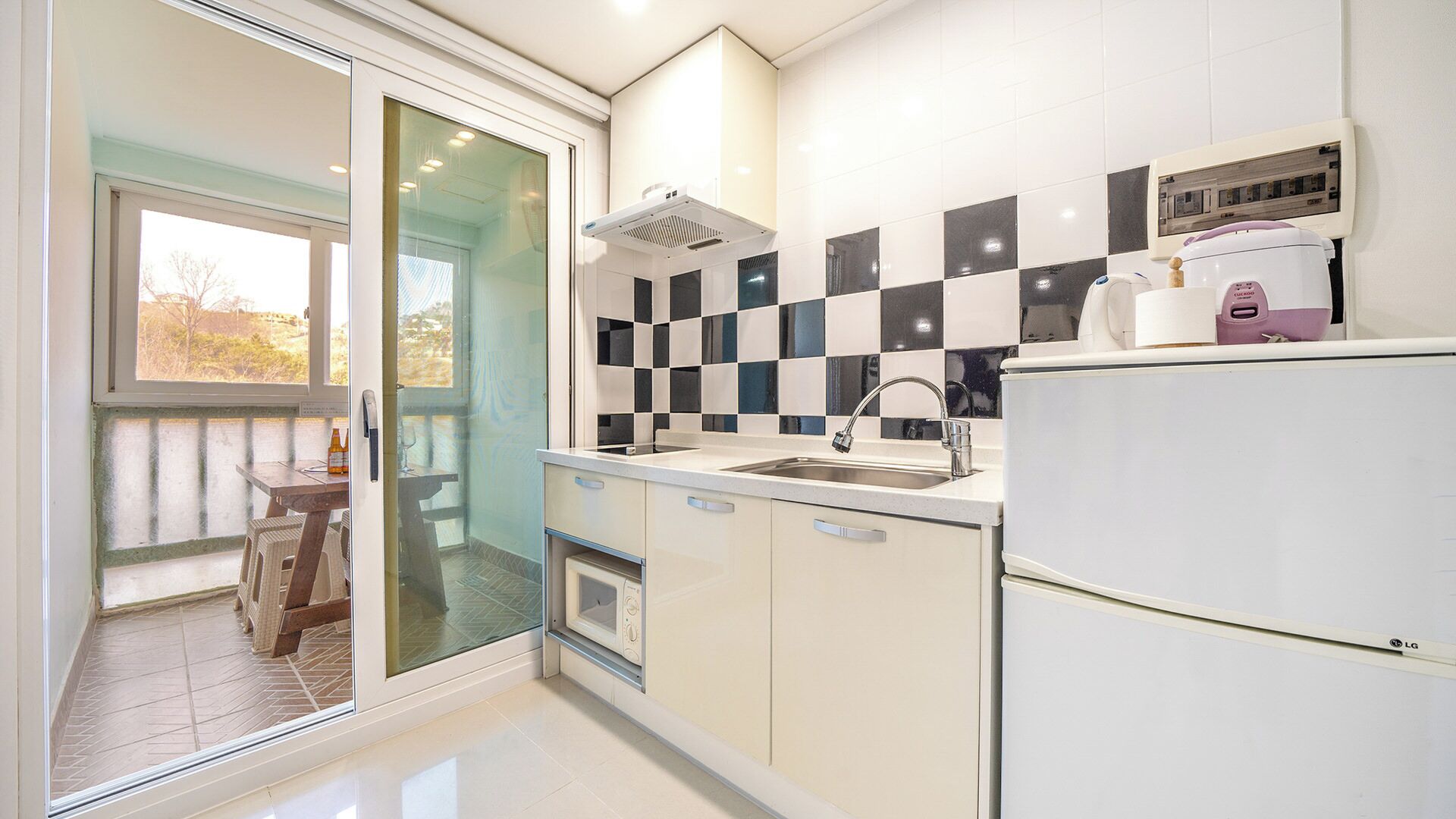 A modern kitchen with a checkered backsplash, a built-in oven, and a refrigerator.