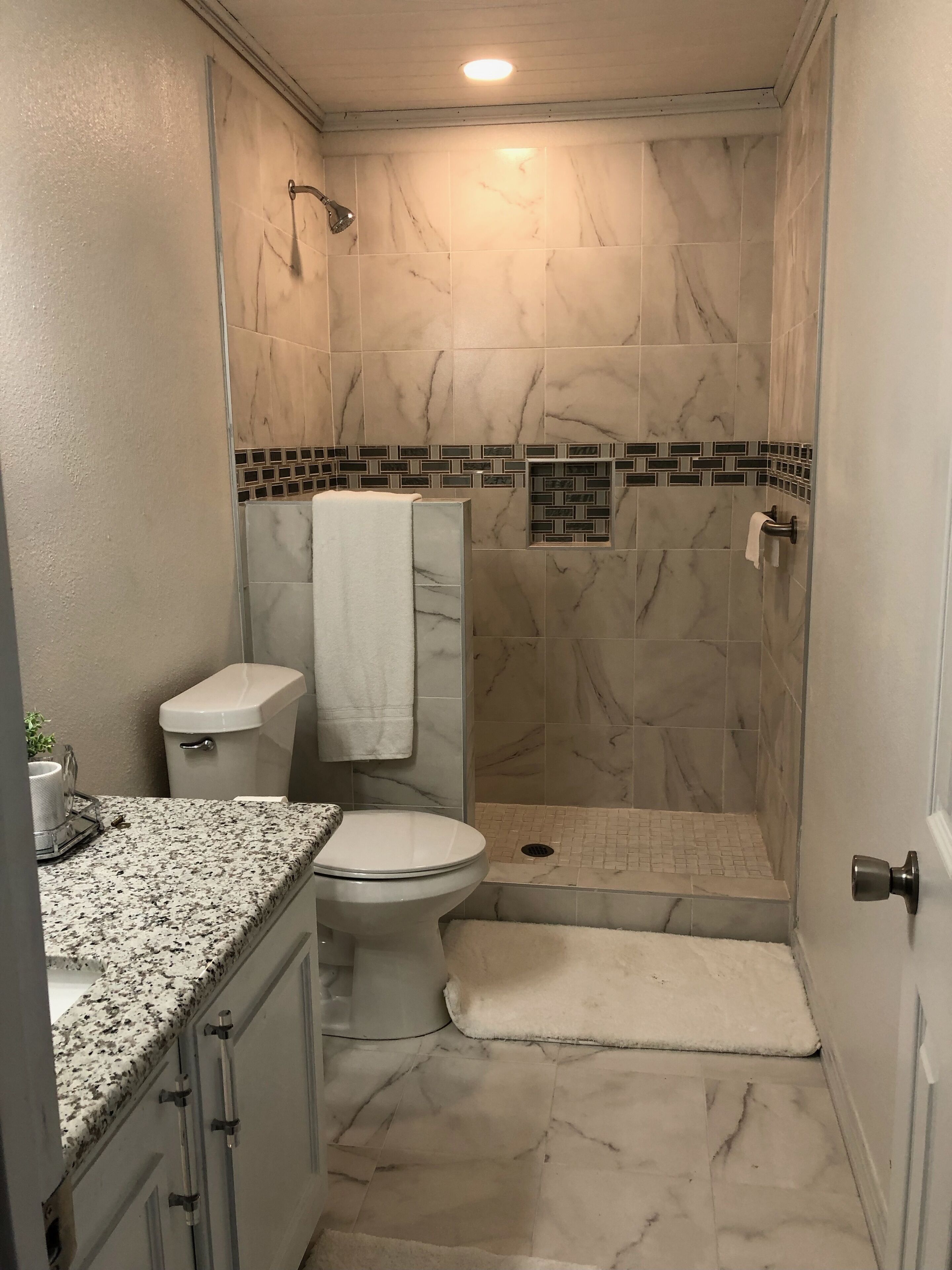 Une salle de bain avec des toilettes, un lavabo et une douche.