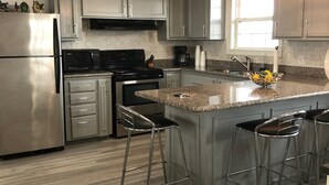Eine moderne Küche mit Edelstahlgeräten, Granit-Arbeitsplatten und Barhocker.