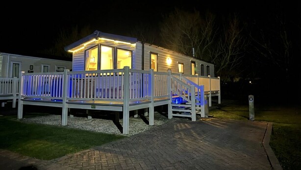 A single-story mobile home with a deck, a covered porch, and a pathway leading to the entrance. - The Lakes Escape Haven Golden Sands Mablethorpe (Mablethorpe)