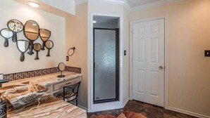 A bathroom with a marble vanity, multiple mirrors, and a glass shower door. - Spacious 7-bedroom, 15-acre estate with private 2-boat and fishing dock! (Alba)