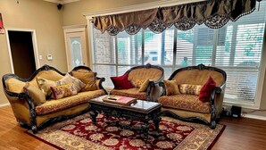A living room with two ornate sofas, a coffee table, and a patterned rug. - Spacious 7-bedroom, 15-acre estate with private 2-boat and fishing dock! (Alba)