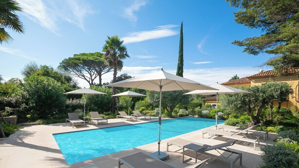 A swimming pool with lounge chairs and umbrellas, surrounded by greenery and a clear sky. - Villa Azzurra Front Beach - Pool, Gassin, France (Gassin)