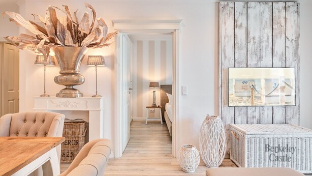 Een moderne woonkamer met een eethoek, een open haard en een grote spiegel aan de muur.