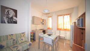 A compact kitchen with a dining area, a sofa, and a television. - Vittorio Veneto 9 Int 20 (Borghetto Santo Spirito)