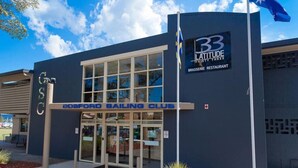 A building with a sign for 'DOSFORD SAILING CLUB' and '33 LATITUDE BRASSERIE RESTAURANT'. - Sailors Cove | Pet Friendly (Point Frederick)