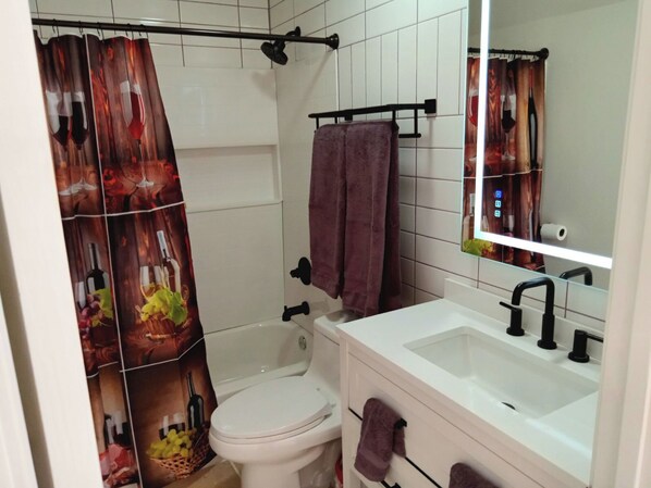 A bathroom with a toilet, sink, and shower area.