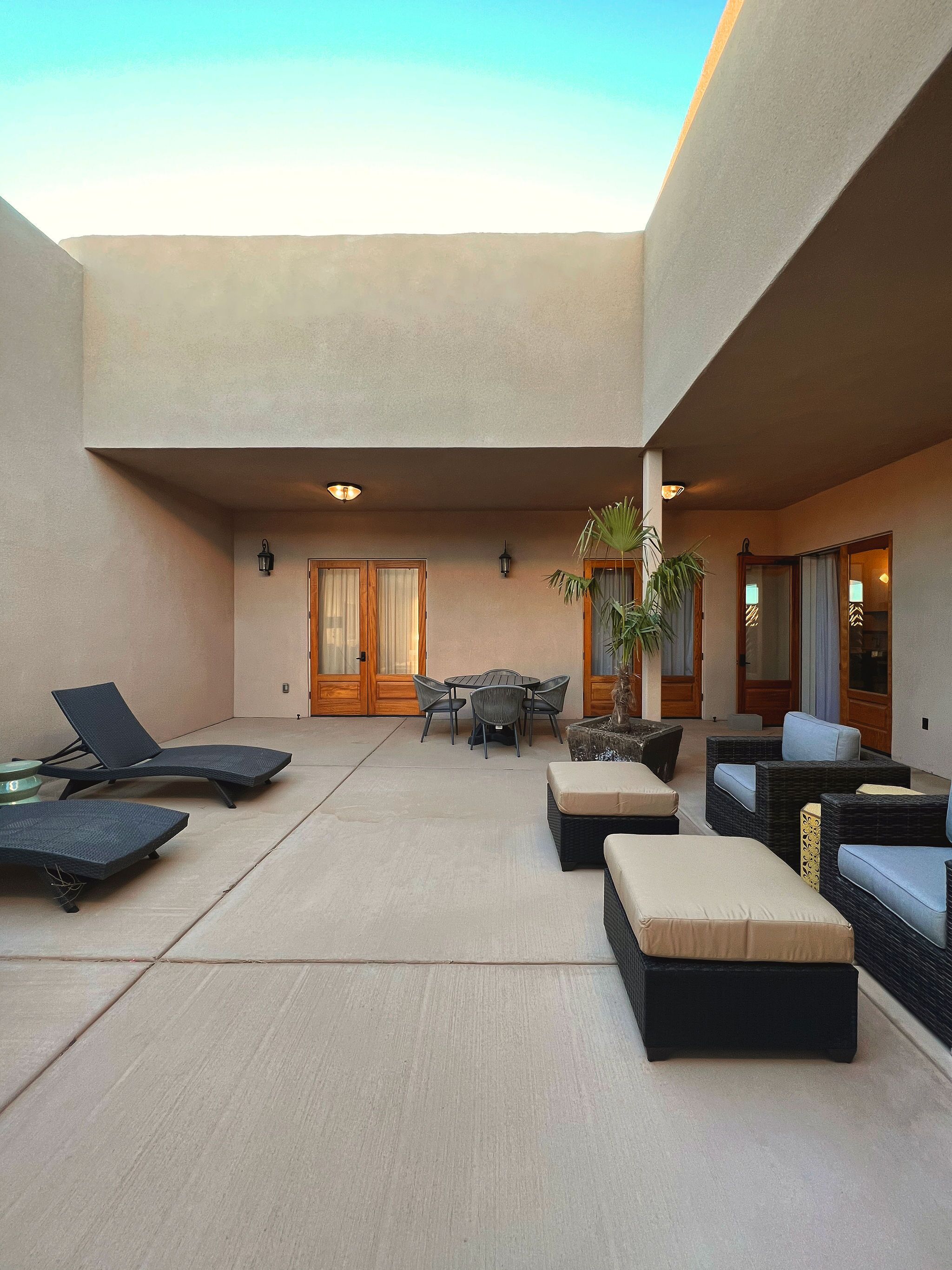 A spacious outdoor area with lounge chairs, a table, and a potted plant.